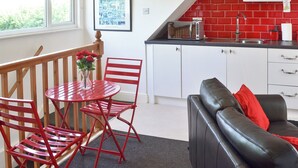 Un espacio habitable compacto con comedor, kitchenette y zona de estar.