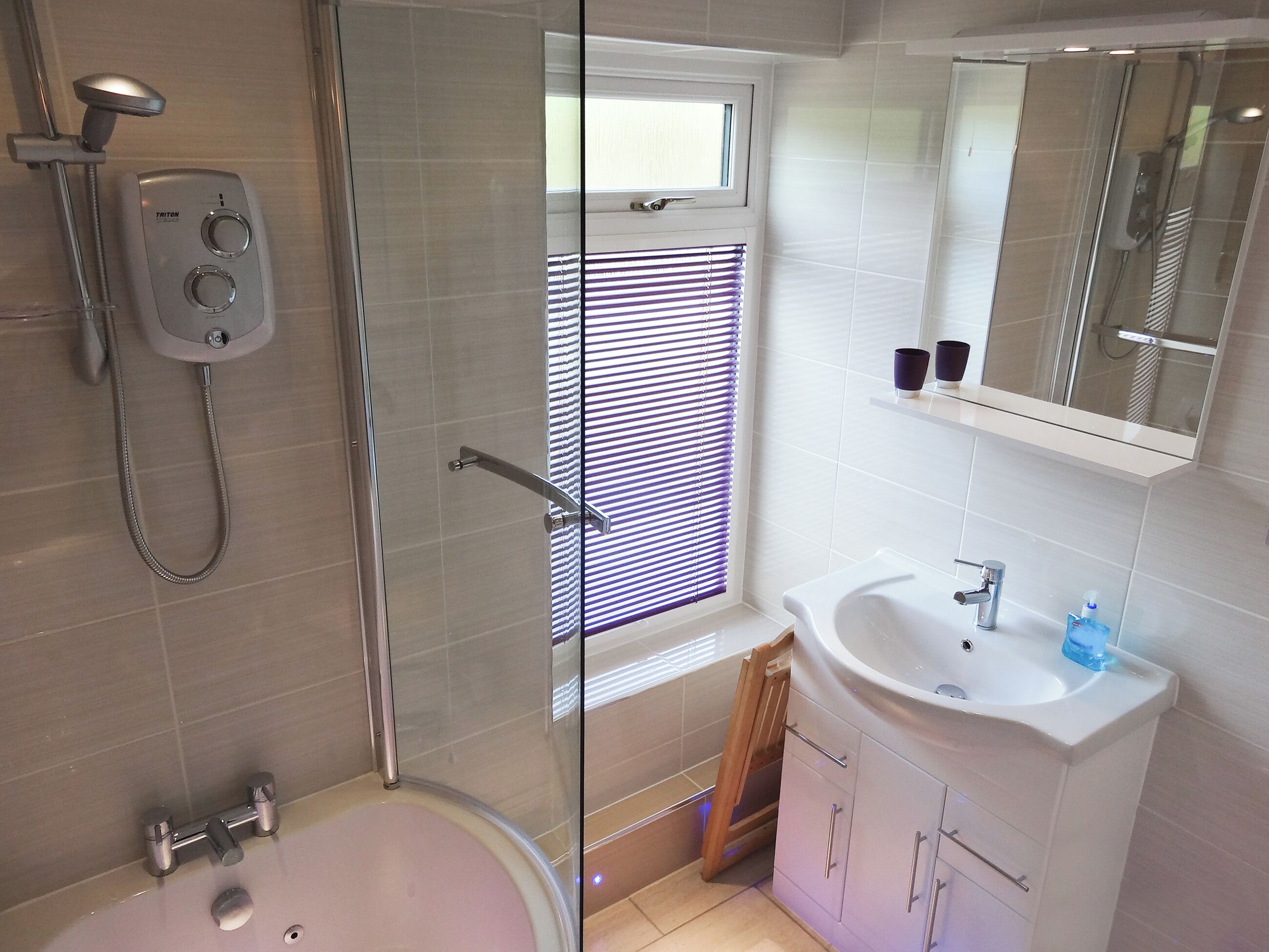 A modern bathroom with a glass-enclosed shower, a bathtub, a sink with a mirror above, and a window with blinds.