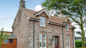 A stone house with a pitched roof, a front door, and a small garden area. - 2 bedroom accommodation in Bigrigg, near Egremont (Bigrigg, near Egremont)
