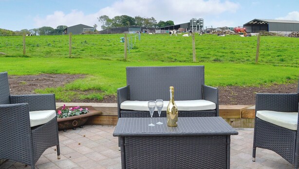 An outdoor seating area with wicker furniture and a bottle of champagne. - 2 bedroom accommodation in Bigrigg, near Egremont (Bigrigg, near Egremont)