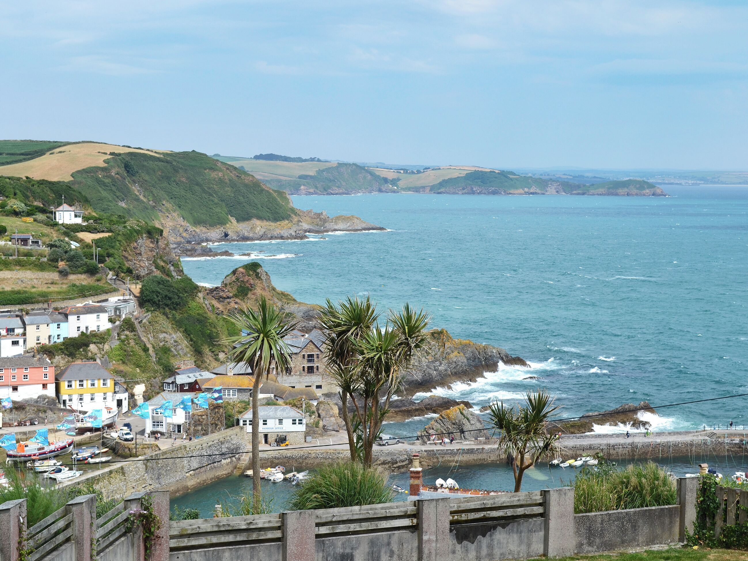 A coastal town with houses, a harbor, and a view of the sea.