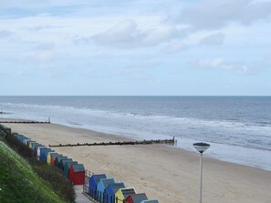A beach with colorful beach huts and a clear view of the sea.