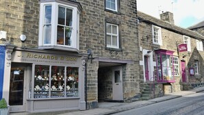 Un bâtiment traditionnel en pierre, avec une devanture de magasin portant l’inscription « J. Richards & Son, bijoutiers et spécialistes des horloges anciennes ».