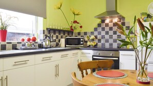 Une cuisine moderne avec des meubles blancs, une table à manger en bois et une fenêtre offrant une belle vue.