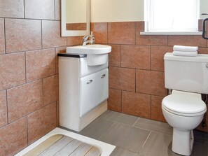 A bathroom with a white sink, mirror, and toilet.
