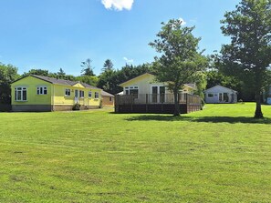 A row of single-story houses with a grassy yard in between.