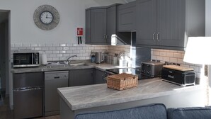 A modern kitchen with grey cabinets, a microwave, a toaster, and a sink.
