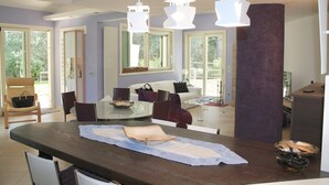 Un comedor moderno con una mesa grande, sillas e iluminación colgante.