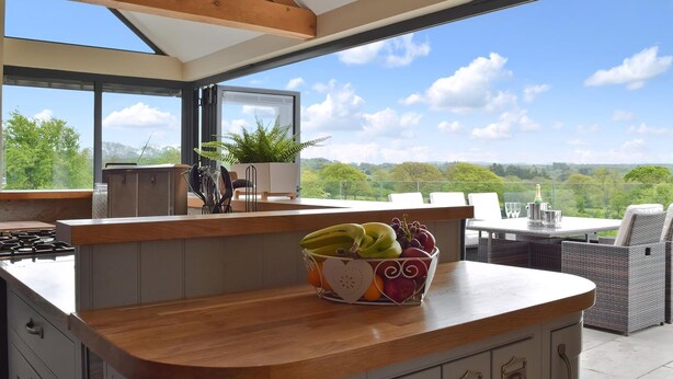 A kitchen with a wooden countertop, a bowl of fruit, and a view of the outdoors. - 5 bedroom accommodation in Llangoedmor, near Cardigan (Llangoedmor, near Cardigan)