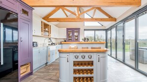 A modern kitchen with a central island, wooden beams, and large windows. - 5 bedroom accommodation in Llangoedmor, near Cardigan (Llangoedmor, near Cardigan)