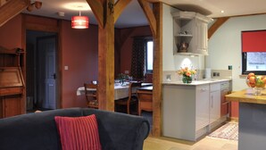 A cozy living room with a sofa and a dining area with a table and chairs. - 3 bedroom accommodation in Ninfield, near Battle (Ninfield, near Battle)