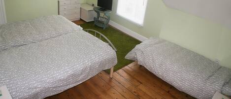 Un dormitorio con dos camas, un escritorio, una silla y una ventana.