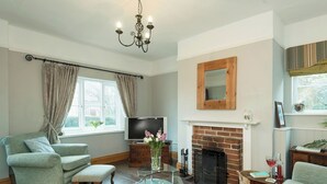 A living room with a fireplace, a television, and a comfortable seating area. - Horseshoe House - UKC2743 (Saham Toney, near Thetford)