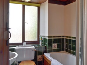 Une salle de bain équipée de toilettes, d’un bidet et d’une baignoire.