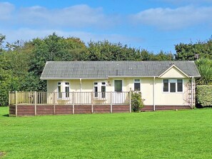 A single-story mobile home with a fenced front yard and a grassy lawn. - 2 bedroom accommodation in Woodacott, near Holsworthy (Woodacott, near Holsworthy)