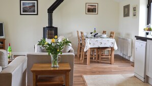 A cozy living room with a fireplace, dining area, and kitchen. - 2 bedroom accommodation in Wadhurst, near Tunbridge Wells (Wadhurst, near Tunbridge Wells)