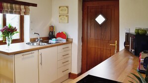 A kitchen with a wooden countertop, a built-in oven, and a window with a view of the outdoors. - A well-appointed, single storey cottage, close to the pretty village of St. (St Merryn, near Padstow)
