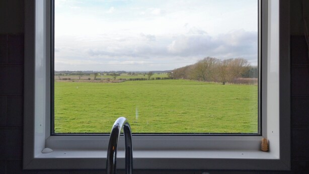 A window with a view of a green field and a cloudy sky. - 1 bedroom accommodation in Fraisthorpe, near Bridlington (Fraisthorpe, near Bridlington)
