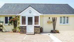 Een huis met een gevel van steen, een witte deur en een klein voortuintje.