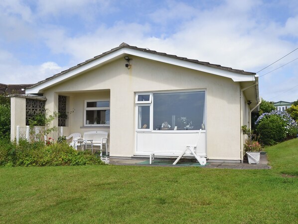 A single-story house with a large window, a small porch with two chairs, and a white fence. - 2 bedroom accommodation in Balwest, near Marazion (Balwest, near Marazion)