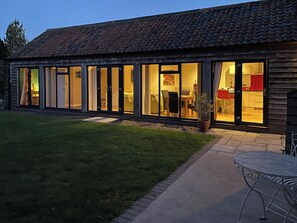 A modern house with large glass doors leading to a dining area and kitchen. - 1 bedroom accommodation in Moorlinch, near Bridgwater (Moorlinch, near Bridgwater)