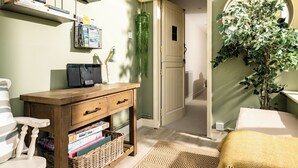 Una habitación acogedora con un escritorio de madera, una cesta de mimbre y una planta.