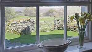 A window with a stone wall and a wooden fence in the view. - Birkerthwaite Farmhouse (Eskdale)