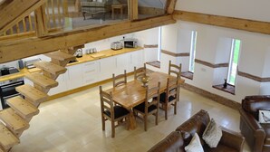 A spacious loft with a dining area, wooden furniture, and a kitchen.