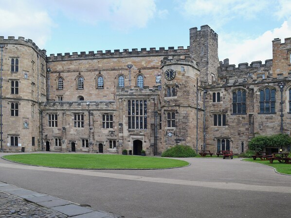 A historic stone building with large windows and a central clock tower.