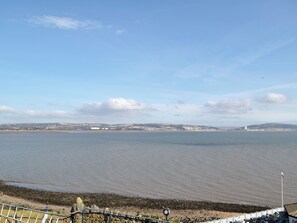 A coastal view with a clear sky, a rocky shoreline, and a distant cityscape. - 2 bedroom accommodation in Rhos, near Pontardawe (Rhos, near Pontardawe)