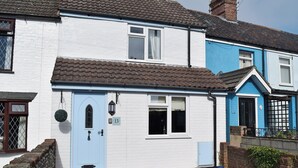 A two-story house with a white exterior and a blue door. - 2 bedroom accommodation in Pakefield, near Lowestoft (Pakefield, near Lowestoft)