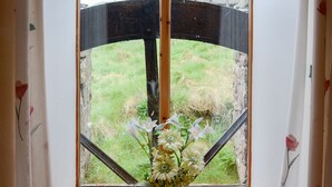A window with a view of a grassy area and a metal structure outside. - 2 bedroom accommodation in John O&rsquo; Groats (John O&rsquo; Groats)