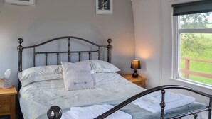 A bedroom with a bed, a bedside table, a lamp, and two framed pictures on the wall. - 3 bedroom accommodation in Bridge of Dee, near Castle Douglas (Bridge of Dee, near Castle Douglas)