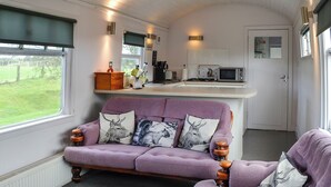 A compact living space with a sofa, a small kitchen area, and a view through a window. - 3 bedroom accommodation in Bridge of Dee, near Castle Douglas (Bridge of Dee, near Castle Douglas)