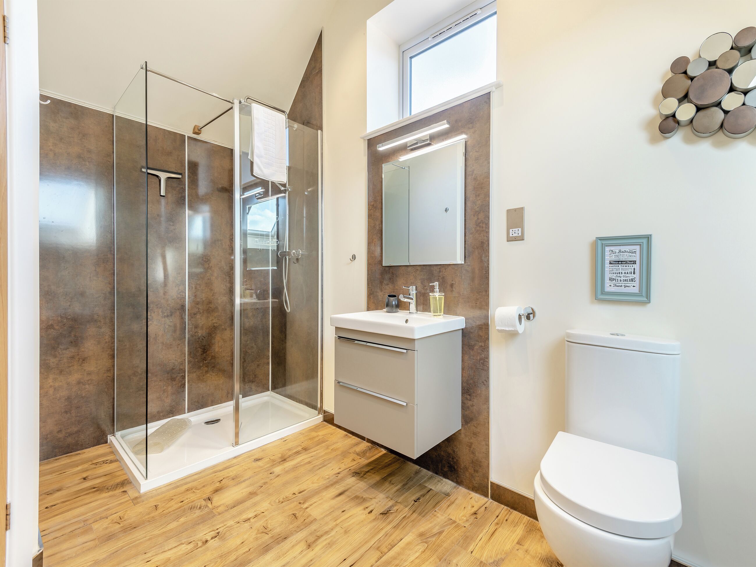 Une salle de bain moderne avec une douche à parois de verre, un lavabo blanc et des toilettes.