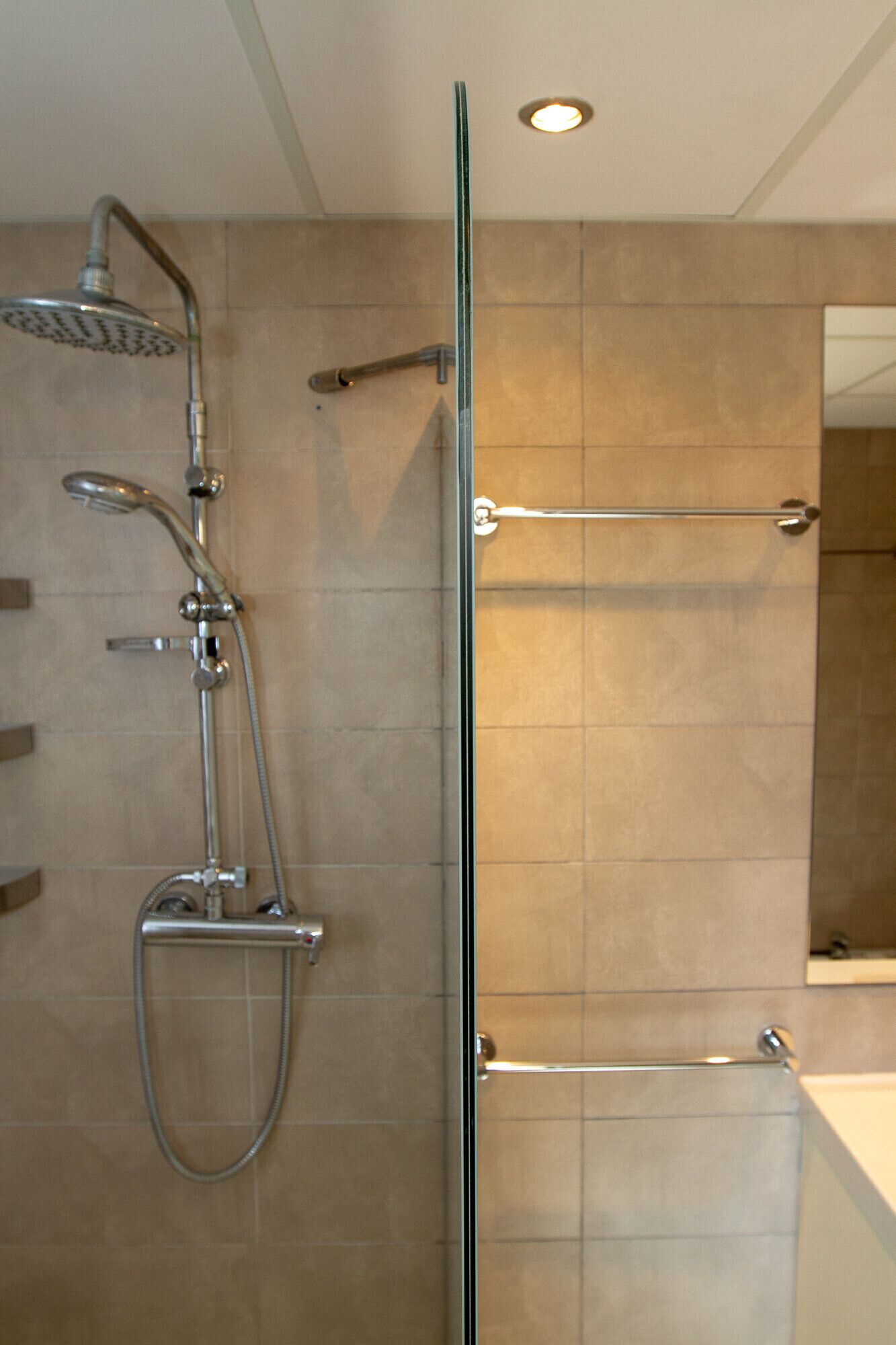Un baño moderno con cabina de ducha de vidrio y ducha de mano.
