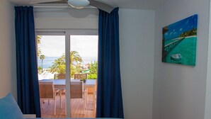 Ein Schlafzimmer mit Bett, Meerblick und einem Strandbild.
