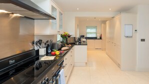 A modern kitchen with stainless steel appliances, a central island, and a view to the dining area. - 7 bedroom accommodation in North Duffield, near York (North Duffield, near York)