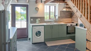 Una cocina compacta con lavadora integrada, un lavabo y una estufa.