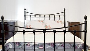 A bed with a floral bedspread and a headboard with a curved design. - 3 bedroom accommodation in Cynheidre, near Llanelli (Cynheidre, near Llanelli)