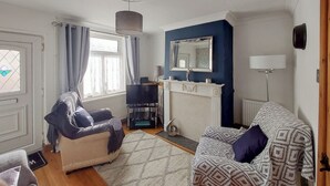 Una sala de estar con chimenea, televisión y sofá.