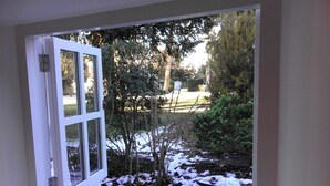 A window with a white frame and a view of a garden with snow on the ground. - Enchanting 17th Century Cotswold Cottage in the beautiful village of Bretforton  (Bretforton, Evesham)