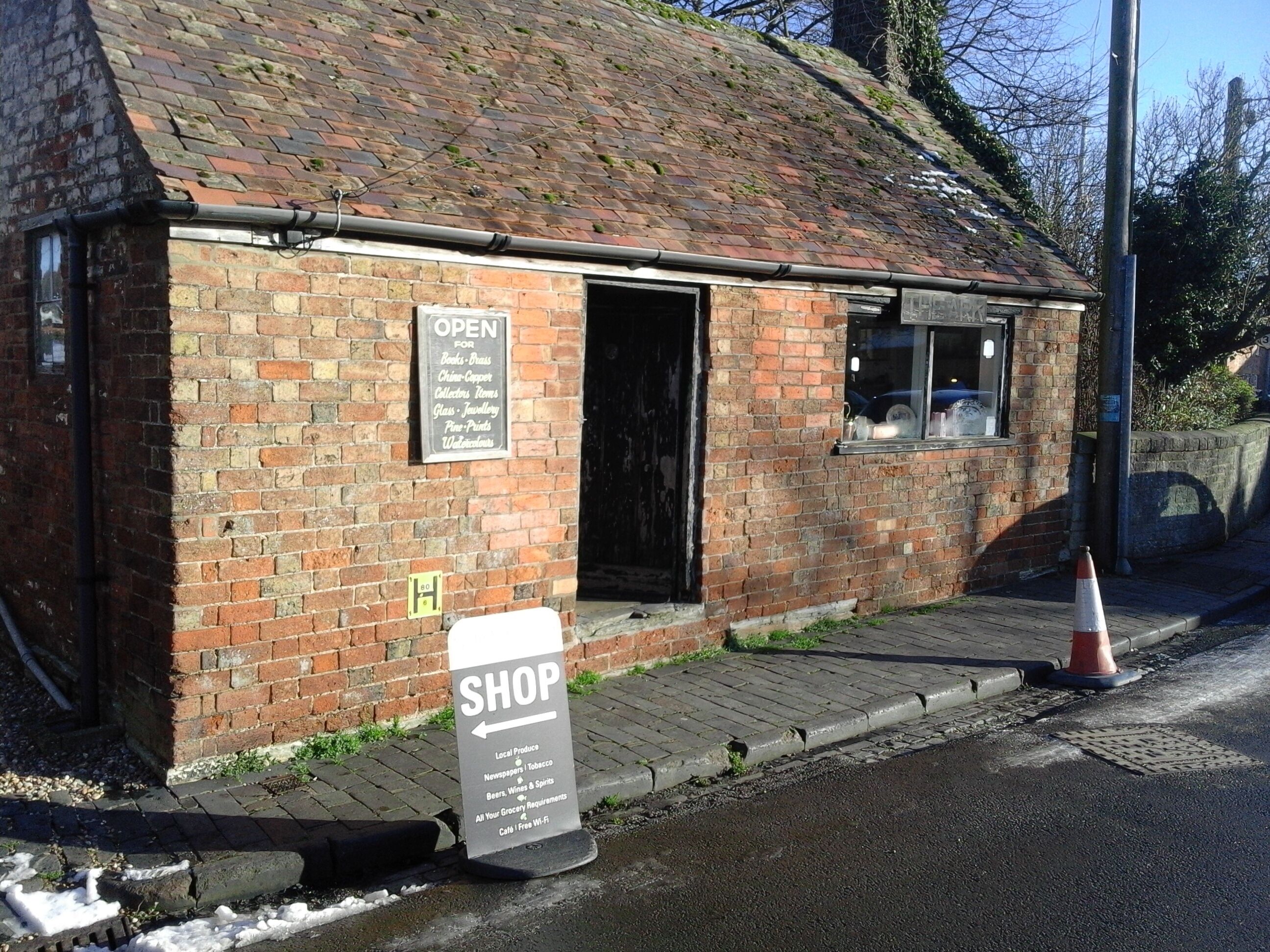 A brick building with a sign indicating it is open for business.