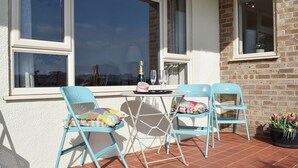 A patio with two blue chairs, a small table, and a potted plant. - 3 bedroom accommodation in near Chipping Warden (near Chipping Warden)