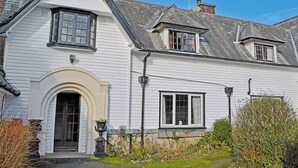 A white two-story house with a gabled roof, a front entrance with an arch, and a small porch. - 3 bedroom accommodation in Llanddona, near Beaumaris (Llanddona, near Beaumaris)