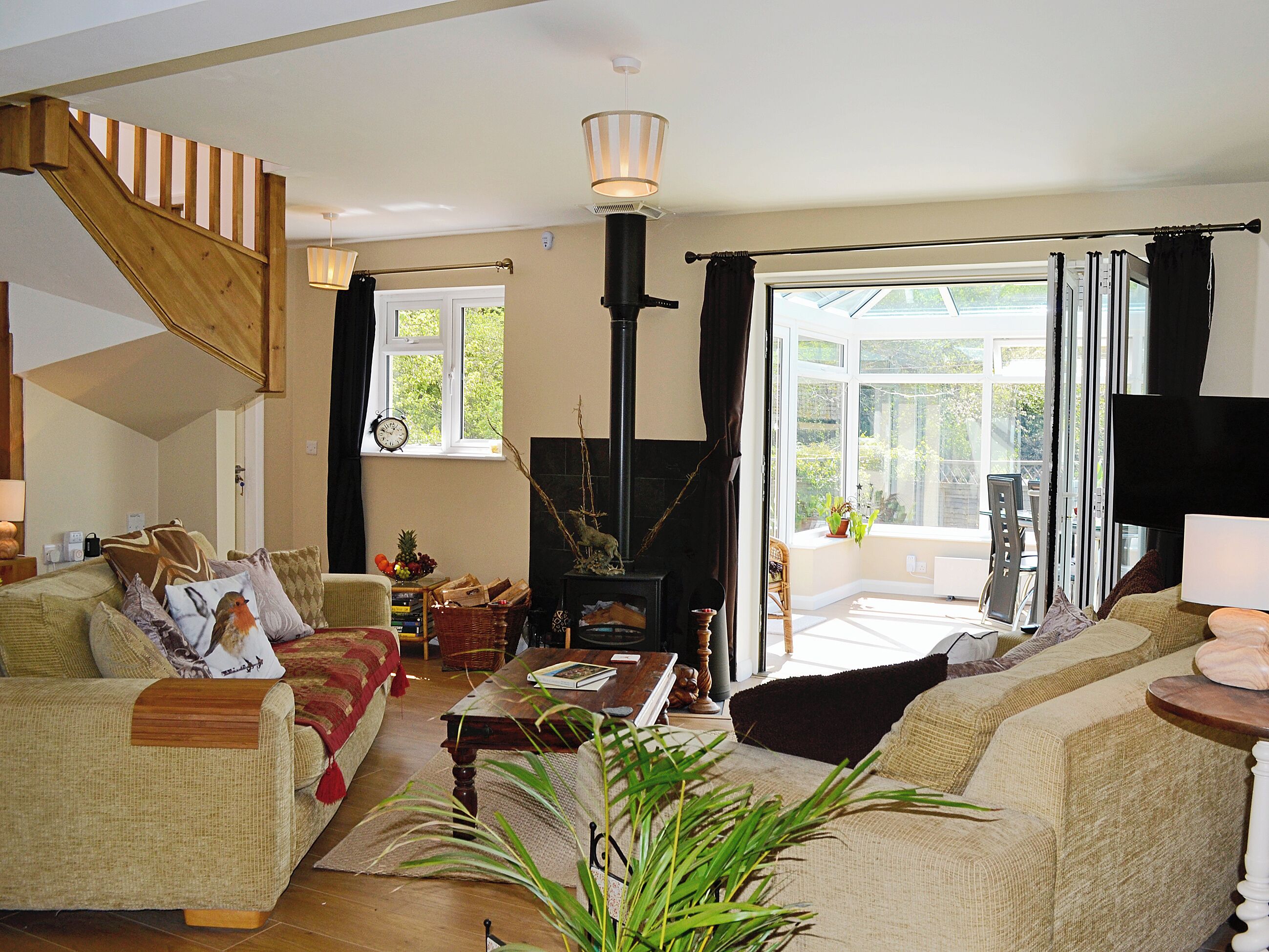 A cozy living room with a fireplace, comfortable seating, and a view of the outdoors.