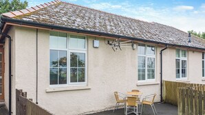 A house with a tiled roof, white exterior walls, and a fenced backyard with a small lawn. - 2 bedroom accommodation in Meathop, near Grange-over-Sands (Meathop, near Grange-over-Sands)