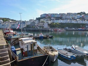 A harbor with boats docked, a flag, and buildings in the background. - 1 bedroom accommodation in Brixham (Brixham)