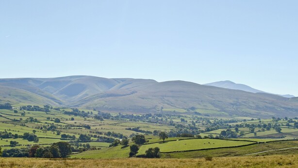 A panoramic view of rolling hills and a distant mountain range under a clear sky. - 2 bedroom accommodation in Caldbeck, near Keswick (Caldbeck, near Keswick)