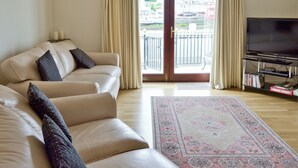 A living room with a sofa, a television, and a view of the outside. - 3 bedroom accommodation in Castletown (Castletown)